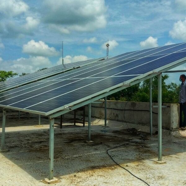 Elevated solar panels installed on a flat, concrete rooftop, with support structure clearly visible.