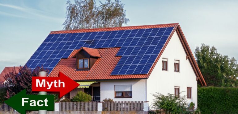 Traditional-style home with rooftop solar panels and a small red 'Myth' sign in the foreground