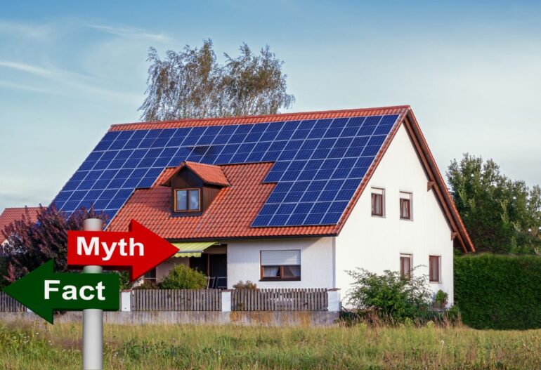 Traditional-style home with rooftop solar panels and a small red 'Myth' sign in the foreground