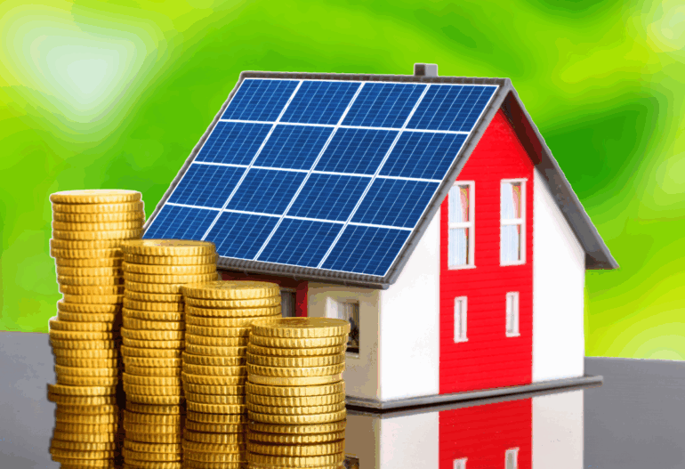 A miniature model house with a solar panel on its roof, sitting on a pile of stacked gold coins, symbolizing financial savings and investment.