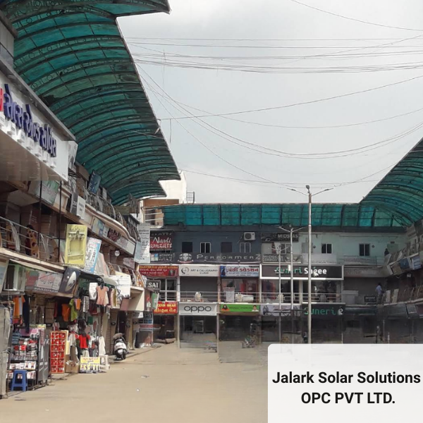 The Bharuch office location for Jalark Solar Solutions OPC Pvt. Ltd., situated on a busy, covered market street with shops on both sides.